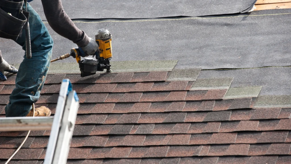 Roofer inspecting a damaged roof in Newport News, VA