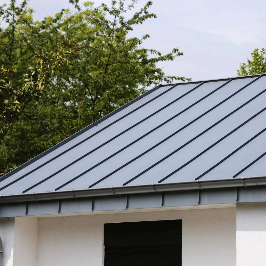 Roofer Hampton VA installing a gray metal roof with standing seams on a modern home.