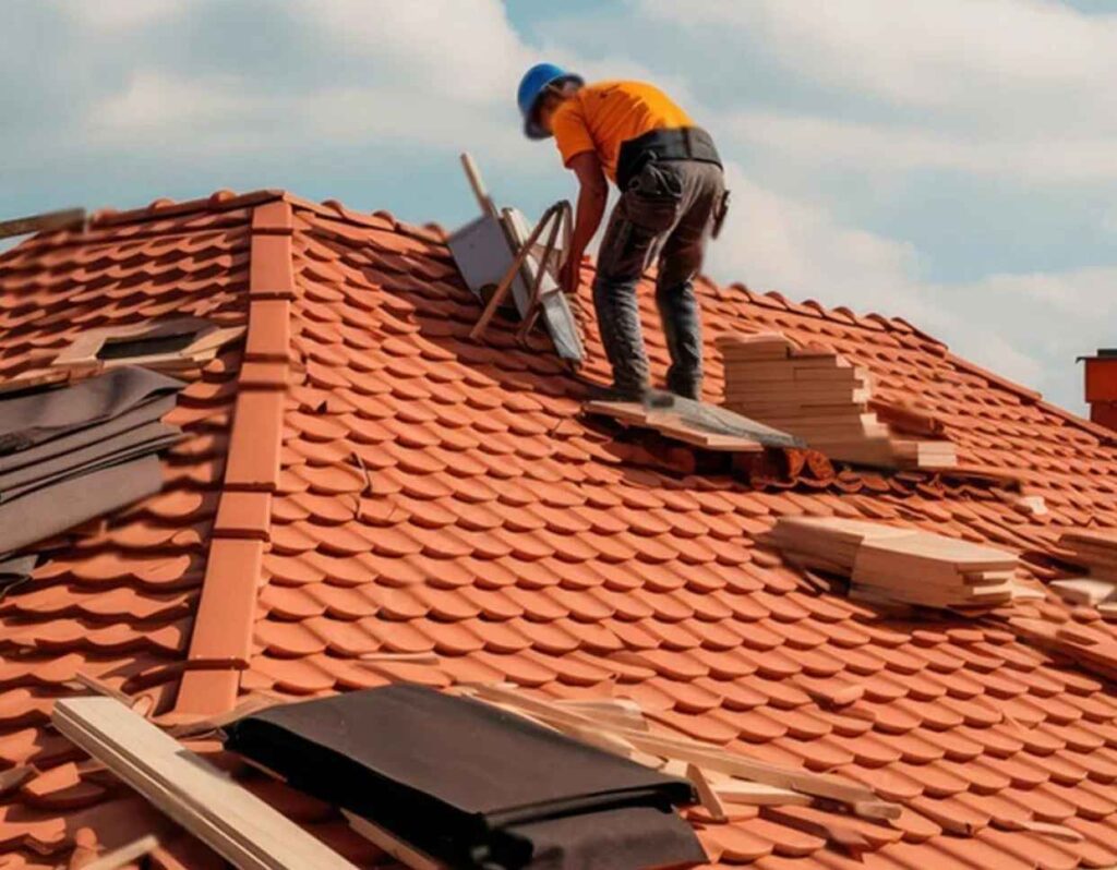 Residential roofing Norfolk worker installing terracotta tile roof.
