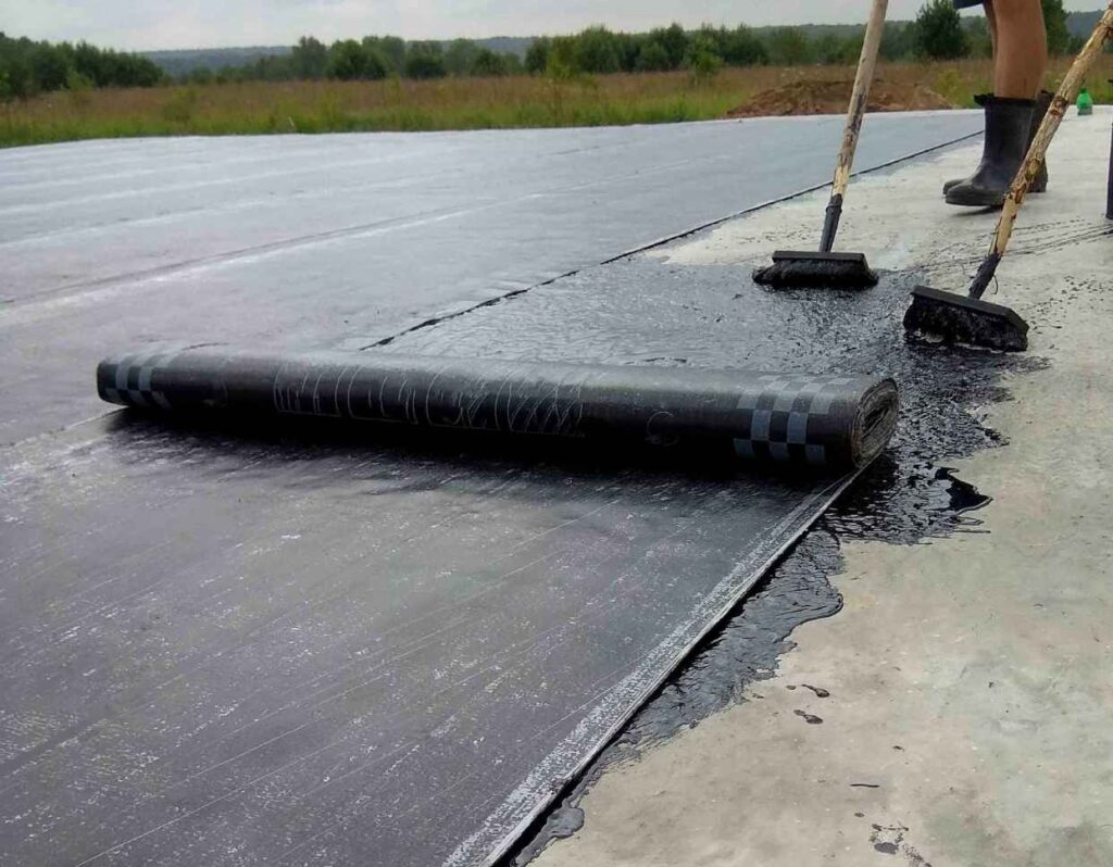 Flat roof installation by a Licensed roofing companies in Portsmouth crew applying rolled asphalt or modified bitumen membrane.
