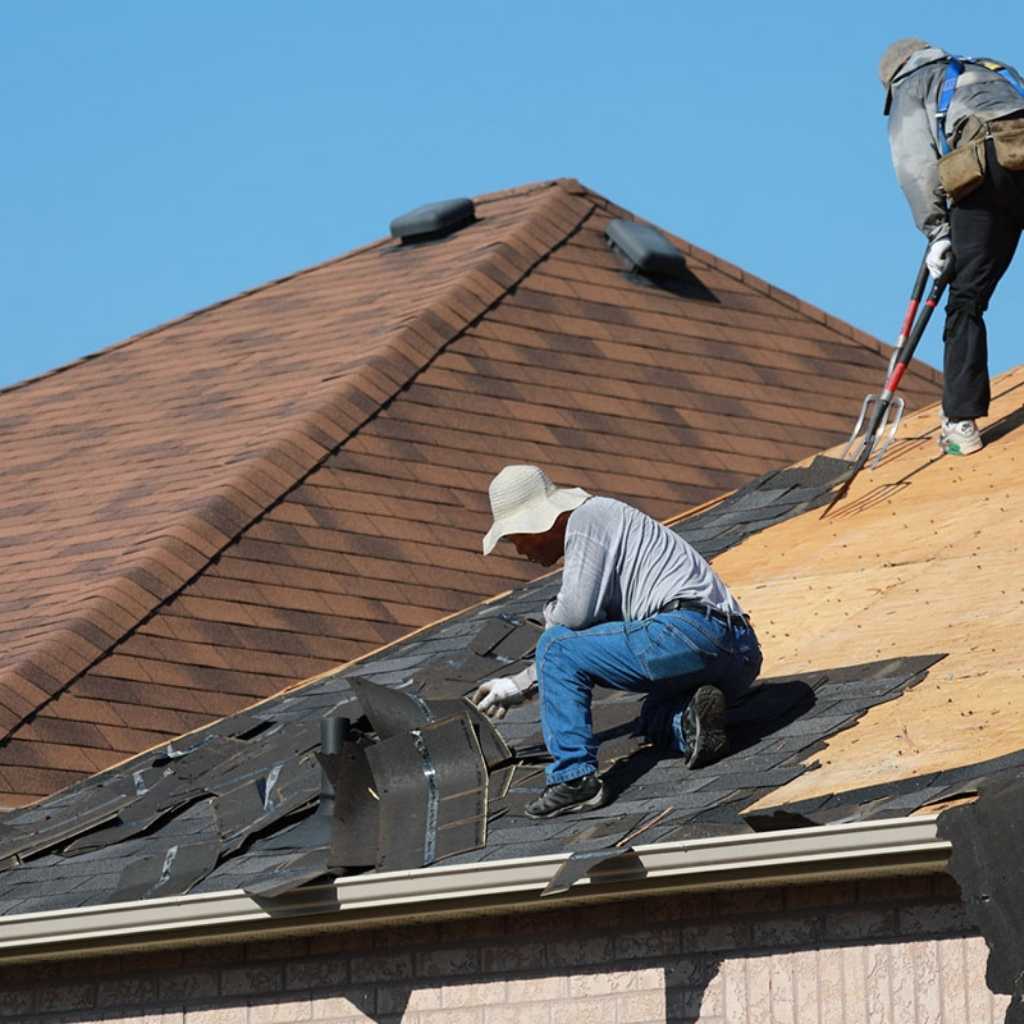 Flat roof repair Portsmouth VA crew performing tear-off and removal of old asphalt shingles for roof replacement.