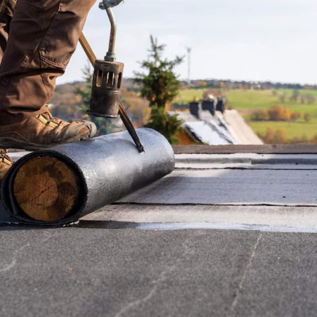 Flat roof installation by a Flat roof repair Newport News VA crew applying rolled asphalt or modified bitumen.
