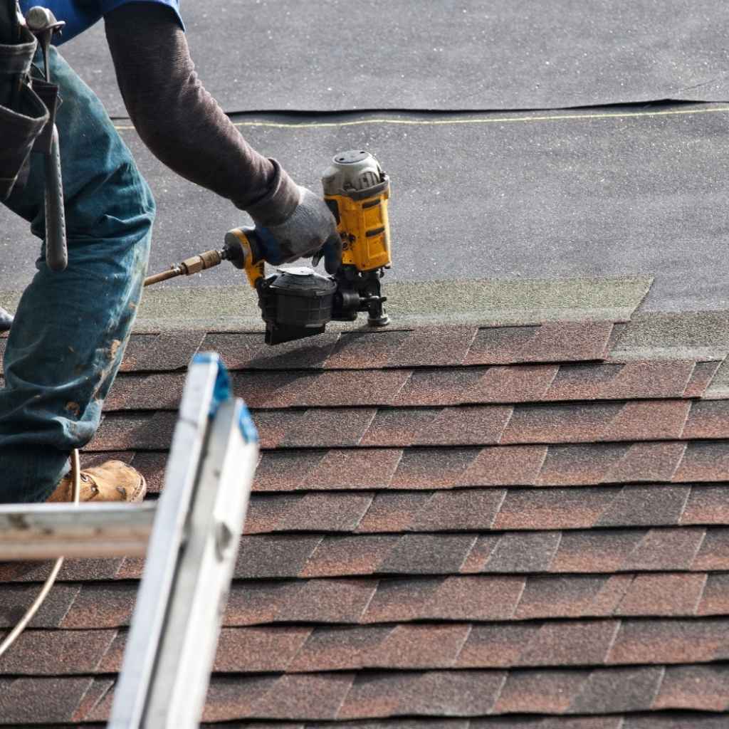 Flat roof repair Suffolk VA crew performing tear-off and installation of asphalt shingles for roof replacement.